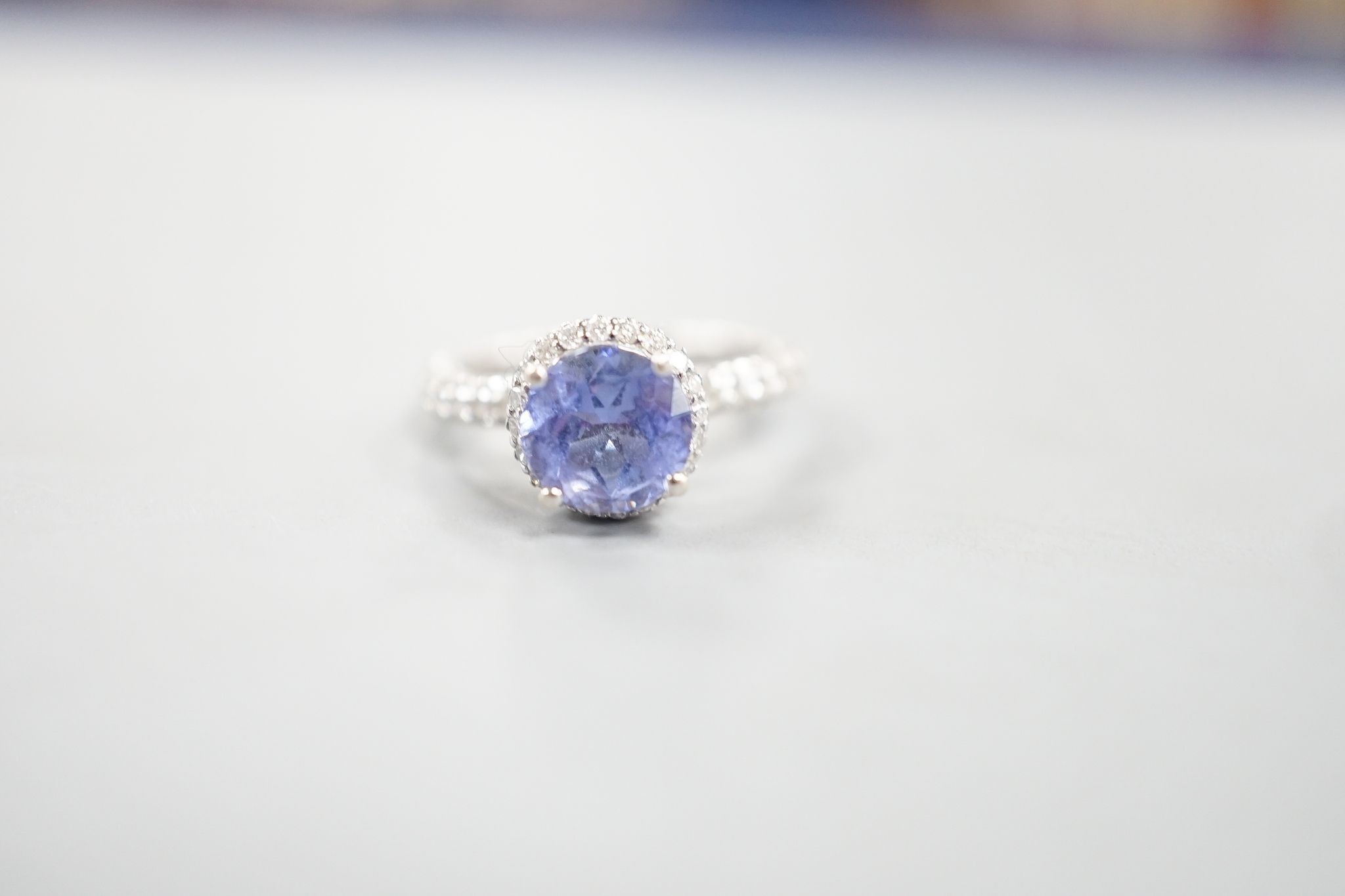 Two modern 18k white metal, tanzanite and diamond set dress rings, size J, gross 8.3 grams and a modern 9ct white gold and gem set ring, gross 2 grams.